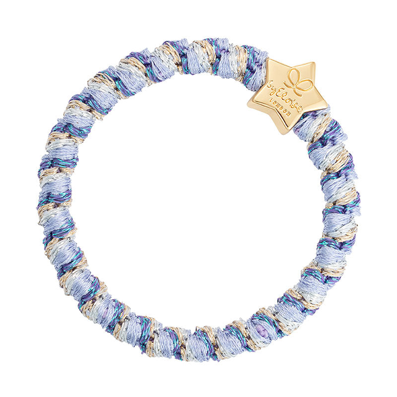 The ByEloise Bangle Band Woven w. Gold Quatrefoil in Ocean Breeze features soft, silk thread in blue, white, and gold shades, accented with a gold quatrefoil charm for an elegant touch.