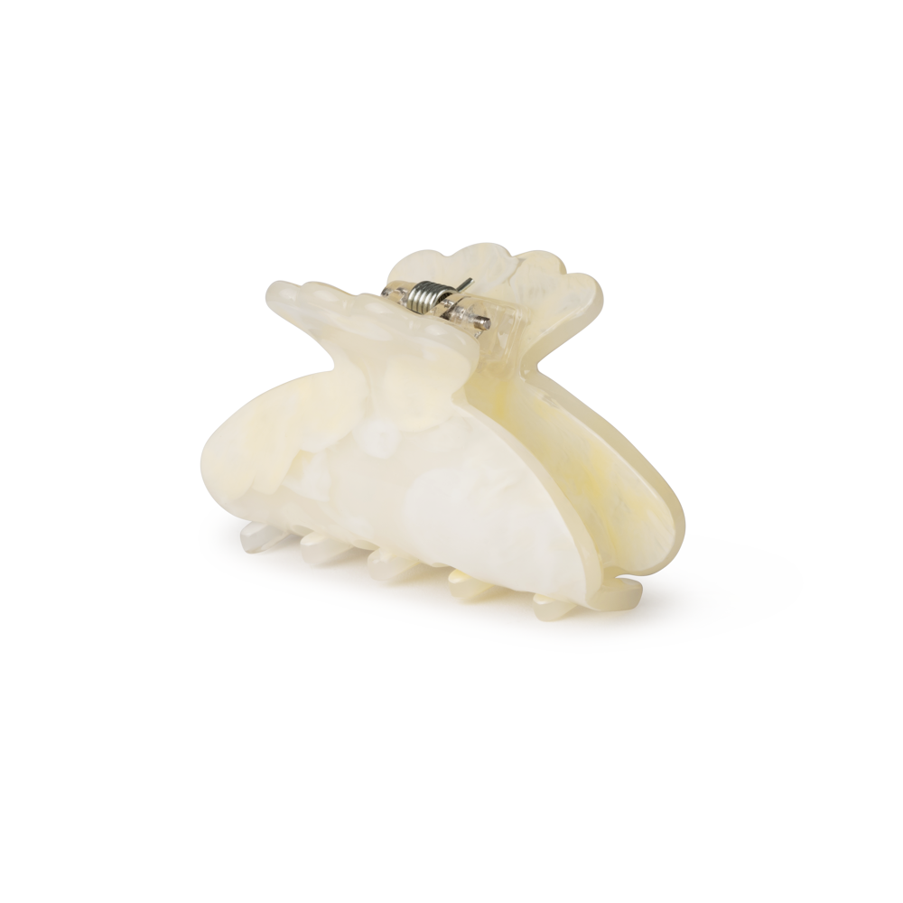 The Sui Ava Helle Arty Mini Hair Claw Clip in Cream is a translucent, off-white curved hair accessory with interlocking teeth, shown against a plain white background.