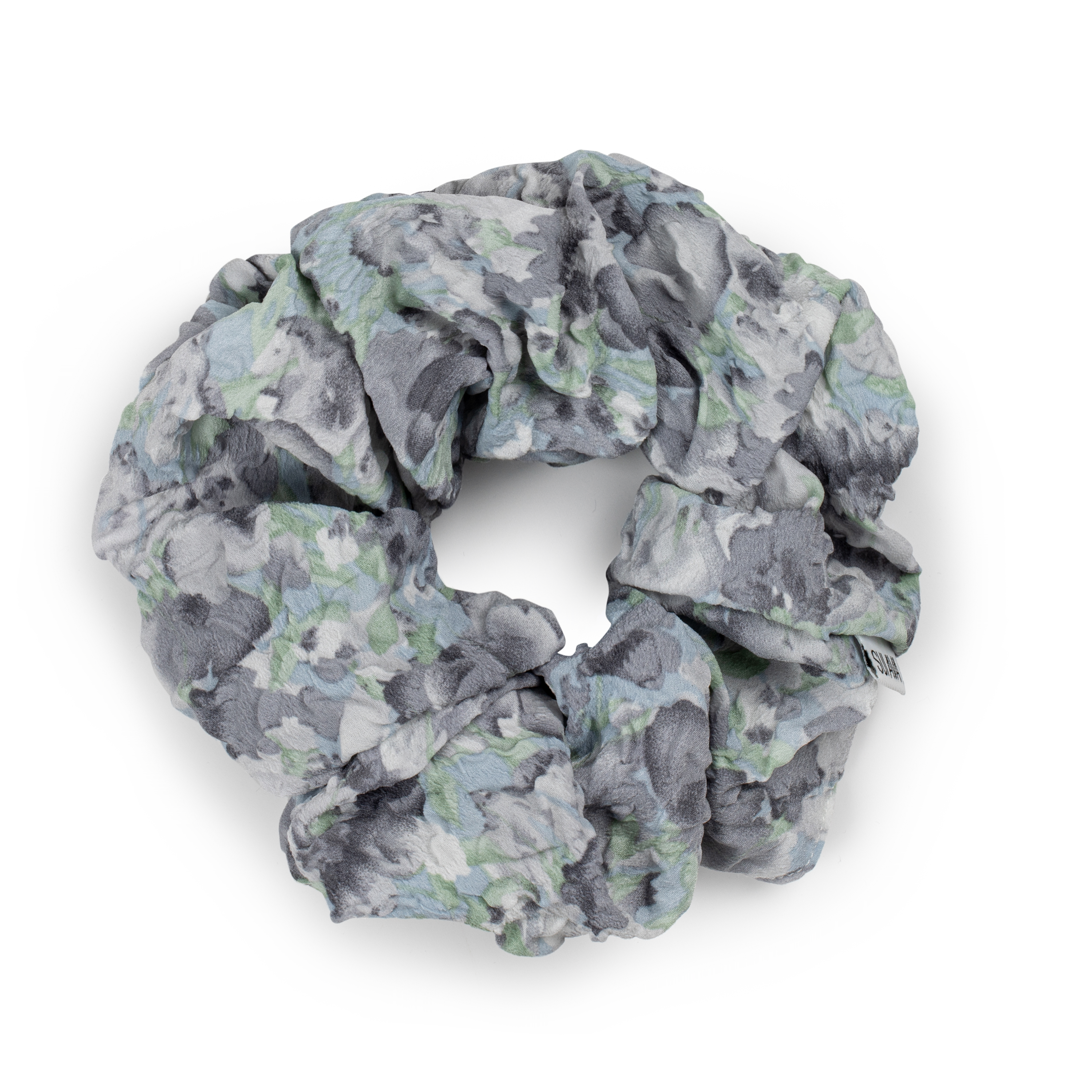 The Julie Wildflower Scrunchie in Steel Grey by Sui Ava features a gray, white, and green floral pattern, arranged in a circle on a white background—a stylish floral hair accessory.