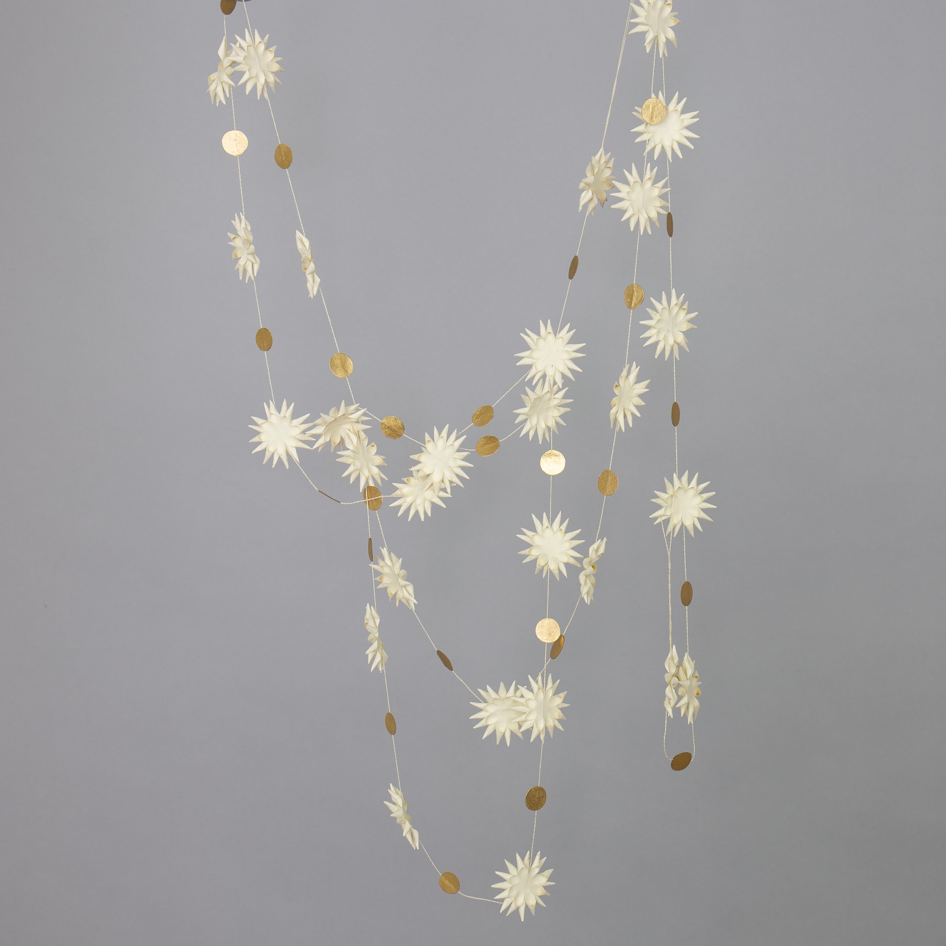 The Kotte Garland in White & Gold by A World of Craft is a handmade paper star garland, perfect as an eco-friendly Christmas decoration.