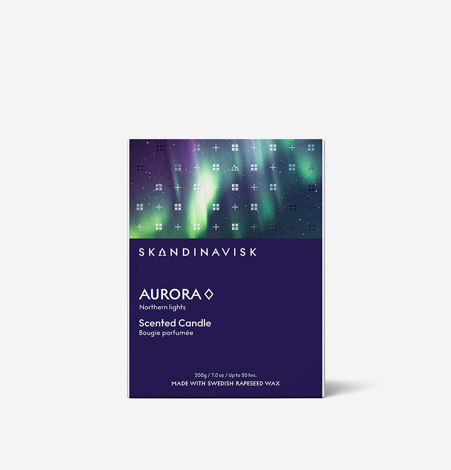 A Skandinavisk Seasonal Aurora Scented Candle (200g, 50h) made with Swedish rapeseed wax, featuring a green and purple aurora design on top and product details on a dark blue background.