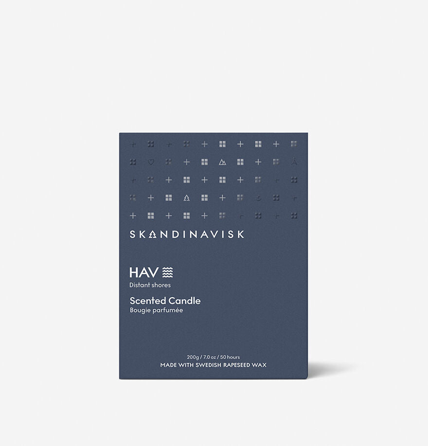 The Skandinavisk Scented Candle Hav 50h, 200g features a navy blue box with minimalist white text and geometric patterns, crafted from Swedish rapeseed wax to evoke the fresh essence of the Scandinavian sea.