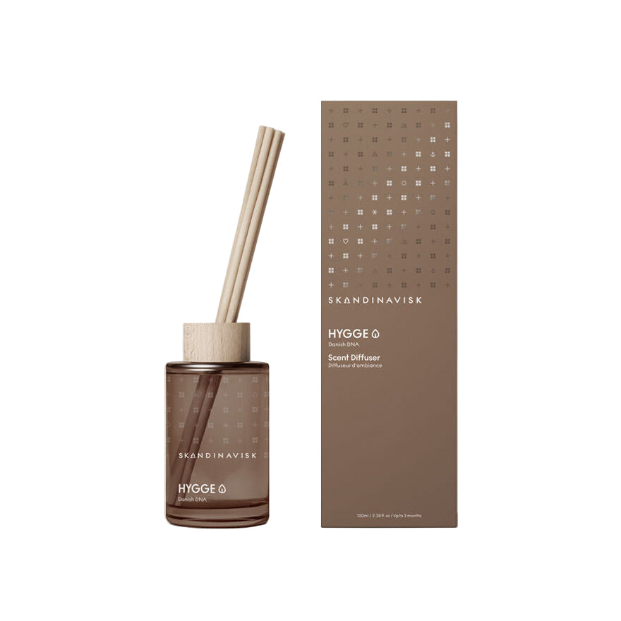 A Skandinavisk Scent Diffuser Hygge (Small) 100 ml, an alcohol-free Danish diffuser with wooden sticks, sits beside its matching box; refill available.