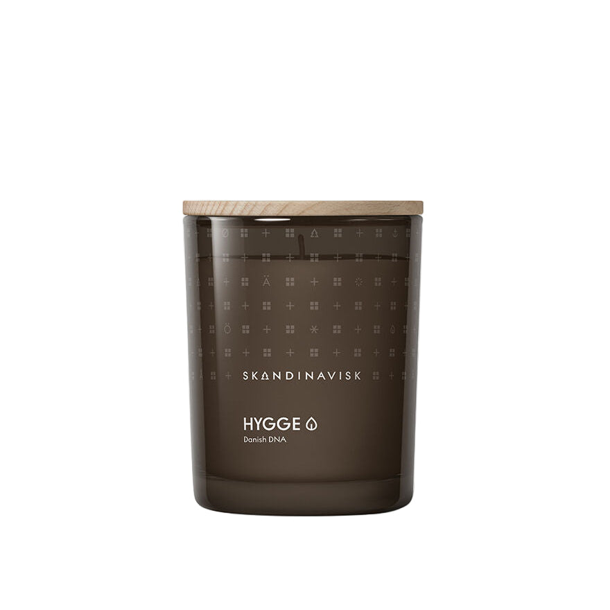 The Skandinavisk Scented Candle Hygge 50h, 200g features a brown glass jar with a wooden lid, capturing Scandinavian hygge and cozy comfort. "SKANDINAVISK HYGGE Danish DNA" is displayed on the front for an authentic touch.