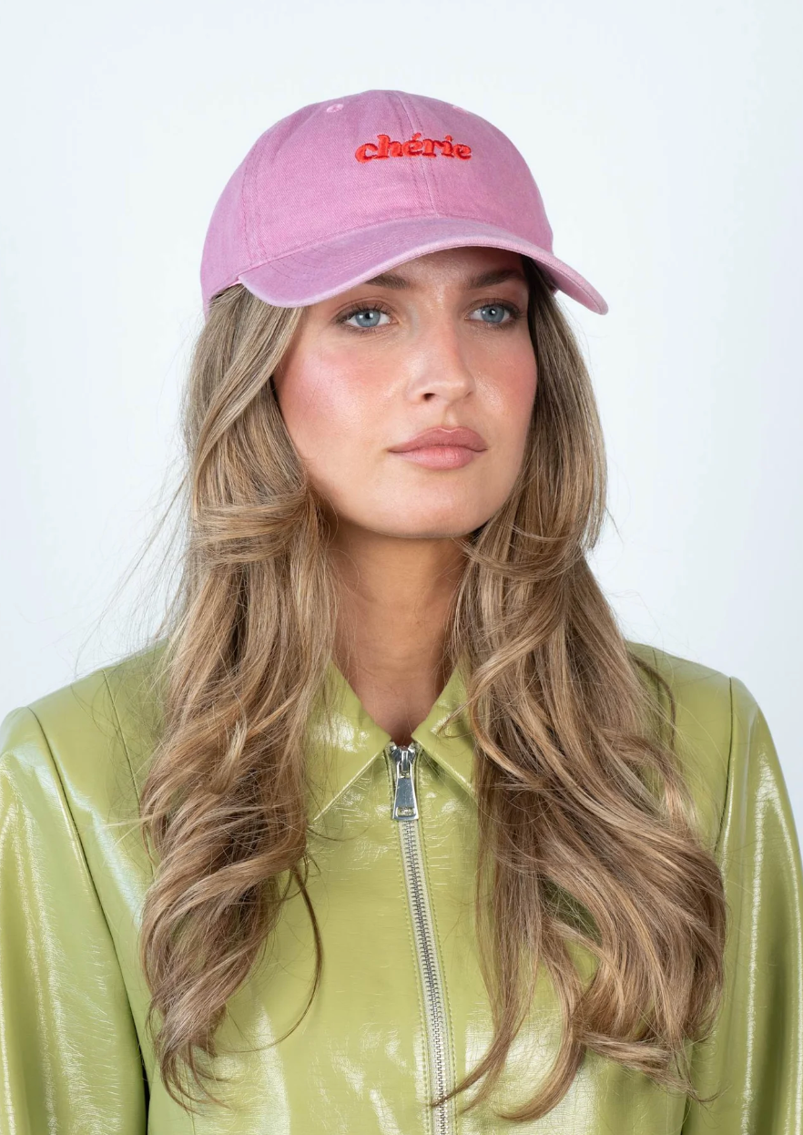 Sui Ava Everyday Cap, Cherie in Light Pink, a cotton cap embroidered with the word chérie in red lettering on the front.