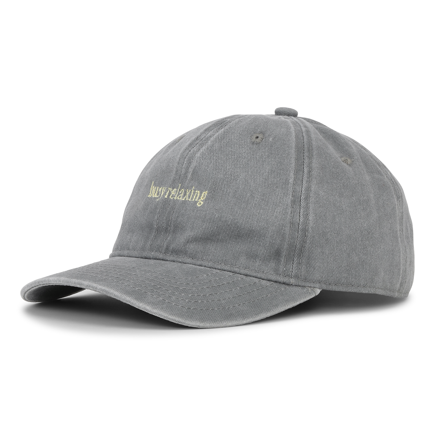 The Soft Served Cap, Busy Relaxing in Liqourice Grey by Sui Ava is a grey embroidered cap with "Busy Relaxing" in light yellow, featuring an adjustable closure for a perfect fit and shown against a plain white background.