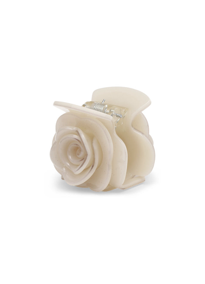 A small, pale cream glitter Rosie Pastel Mini Hair Claw Clip in Cream Glitter Pink shaped like a blooming rose.