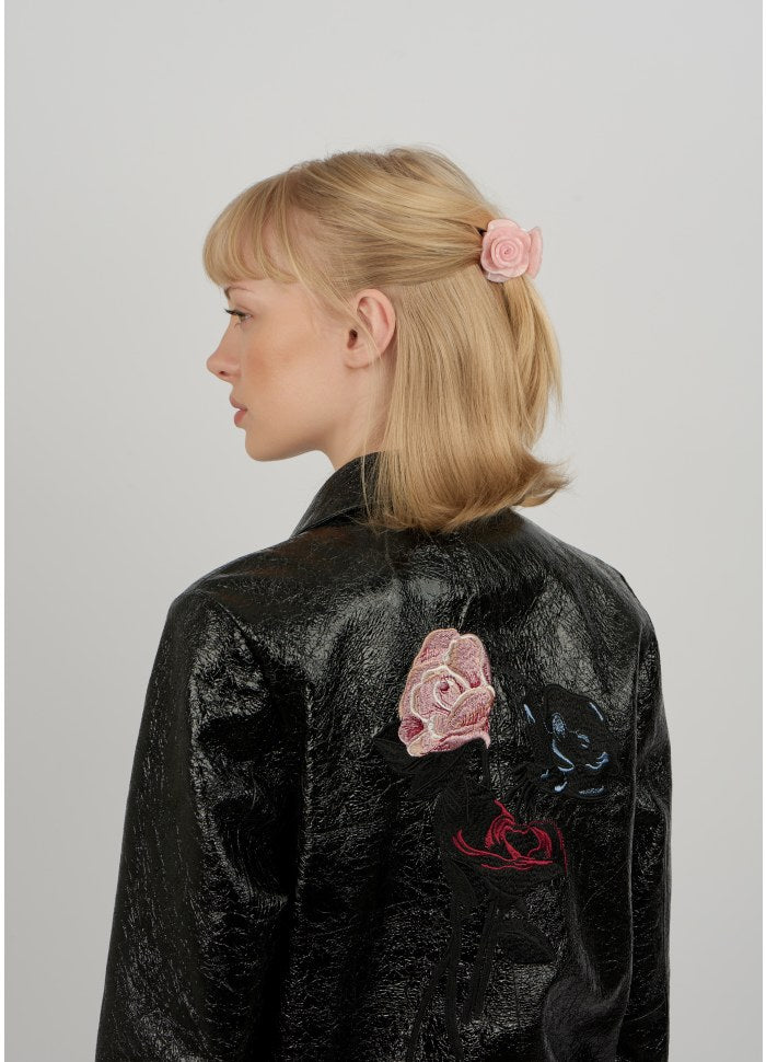 A millennial pink Rosie Mini Hair Claw Clip by Sui Ava holding back a section of blonde hair.