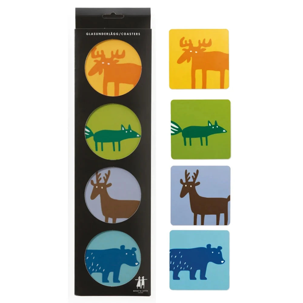 Four vibrant coasters from the Bengt & Lotta Wild Animal Coasters Birchwood Set of 4 are displayed: orange moose, green fox, brown deer, and blue bear. Showcasing bold wild animal artwork inspired by Scandinavian design, these birchwood coasters are pictured both inside and outside their packaging.